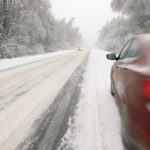 Red car driving in the snow