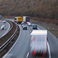 Image of cars and trucks traveling fast on a highway, representing a common cause of WV truck accidents.