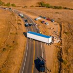 California Highway Traffic. Trucks and cars on the Highway 1 are stuck because of the accident. Huge truck blocked the road both ways. American transportation theme.