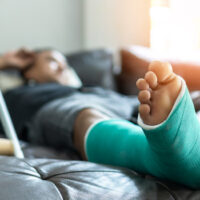 A man with his foot in a cast, representing the questions you may have for a WV personal injury lawyer.