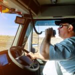 Truck drivers big truck right-hand traffic hands holding radio and steering wheel truck dashboard with driver