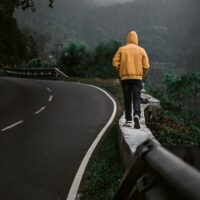 Person walking beside a roadway, representing the ways WV pedestrian accident lawyers help after pedestrian crashes.